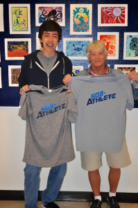 Patrick Breslin and Kim Short holding t-shirts with logo designed by Patrick!